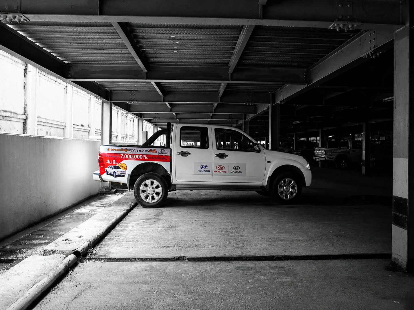 Printed KOLAO promotional graphic attached to a pickup vehicle